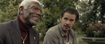 Movie still from “Raymond & Ray” (2022), directed by Rodrigo García – A man with a cross on his forehead and a man with a beard and mustache; Close Up shot, Over the shoulder angle