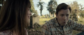 Movie still from “Raymond & Ray” (2022), directed by Rodrigo García – A man and a woman sitting in front of each other in a cemetery; Close Up shot, Over the shoulder angle