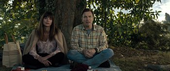 Movie still from “Raymond & Ray” (2022), directed by Rodrigo García – A man and a woman sitting next to a tree; Medium shot, Over the shoulder angle