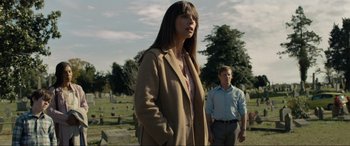 Movie still from “Raymond & Ray” (2022), directed by Rodrigo García – A woman and a man standing in front of a cemetery; Medium shot, Low angle