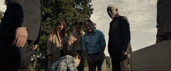 Movie still from “Raymond & Ray” (2022), directed by Rodrigo García – A group of people standing next to each other in a park; Medium shot, Low angle