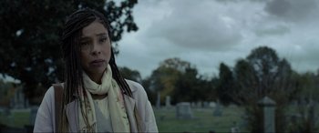 Movie still from “Raymond & Ray” (2022), directed by Rodrigo García – A woman with dreadlocks standing in a cemetery; Close Up shot, Low angle