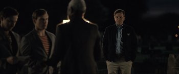 Movie still from “Raymond & Ray” (2022), directed by Rodrigo García – A man standing in front of another man in the dark; Medium shot, Over the shoulder angle