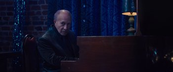 Movie still from “Raymond & Ray” (2022), directed by Rodrigo García – An older man sitting in front of an upright piano; Medium shot, High angle