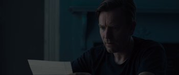 Movie still from “Raymond & Ray” (2022), directed by Rodrigo García – A man sitting in front of a piece of paper; Close Up shot, Over the shoulder angle