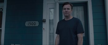 Movie still from “Raymond & Ray” (2022), directed by Rodrigo García – A man standing in front of a door way; Medium shot, Low angle