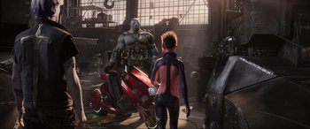 Movie still from “Ready Player One” (2018), directed by Steven Spielberg – A woman standing next to a man in a garage; Wide shot, Over the shoulder angle