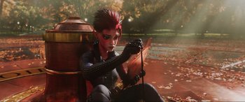 Movie still from “Ready Player One” (2018), directed by Steven Spielberg – A woman with red and black hair sitting on the side of a fire hydrant; Medium shot, High angle