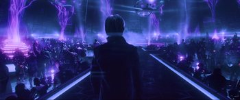 Movie still from “Ready Player One” (2018), directed by Steven Spielberg – A man standing in front of an audience in a dark room; Wide shot, Low angle