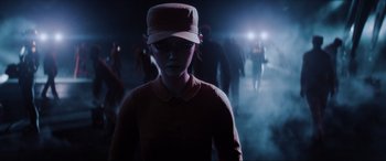 Movie still from “Ready Player One” (2018), directed by Steven Spielberg – A person wearing a hat standing next to a group of people; Wide shot, Low angle