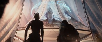 Movie still from “Ready Player One” (2018), directed by Steven Spielberg – Two people are watching a large screen television; Medium shot, Over the shoulder angle
