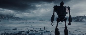 Movie still from “Ready Player One” (2018), directed by Steven Spielberg – Two people standing in the snow near a giant robot; Extreme Wide shot, Low angle