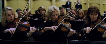 Movie still from “Red Dragon” (2002), directed by Brett Ratner – A group of people playing musical instruments in an orchestra; Close Up shot, Low angle