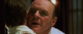 Movie still from “Red Dragon” (2002), directed by Brett Ratner – An older man with blue eyes looking at the camera; Close Up shot, Over the shoulder angle