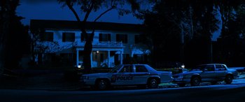 Movie still from “Red Dragon” (2002), directed by Brett Ratner – A police car parked on the side of the street; Wide shot, Low angle