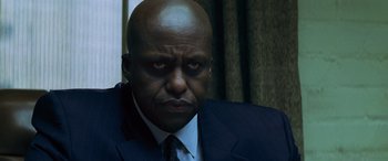 Movie still from “Red Dragon” (2002), directed by Brett Ratner – A man in a suit and tie looking at the camera; Close Up shot, Low angle