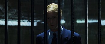 Movie still from “Red Dragon” (2002), directed by Brett Ratner – A man wearing a suit and tie behind bars; Close Up shot, Low angle