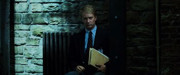 Movie still from “Red Dragon” (2002), directed by Brett Ratner – A man in a suit and tie holding a folder; Medium shot, Low angle