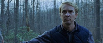 Movie still from “Red Dragon” (2002), directed by Brett Ratner – A person wearing a jacket near a forest; Close Up shot, Low angle