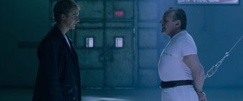 Movie still from “Red Dragon” (2002), directed by Brett Ratner – Two men are standing next to each other in a dark room; Medium shot, Over the shoulder angle