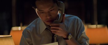 Movie still from “Red Dragon” (2002), directed by Brett Ratner – A man talking on a phone while sitting at a desk; Close Up shot, Low angle
