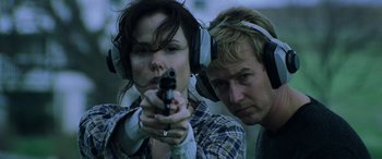 Movie still from “Red Dragon” (2002), directed by Brett Ratner – A man and a woman wearing ear muffs and holding a gun; Close Up shot, Low angle
