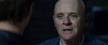 Movie still from “Red Dragon” (2002), directed by Brett Ratner – An older man with a goatee looking at the camera; Close Up shot, Over the shoulder angle