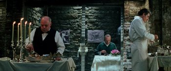 Movie still from “Red Dragon” (2002), directed by Brett Ratner – Two people sitting at a table with a plate of food; Medium shot, Over the shoulder angle