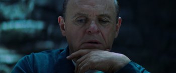 Movie still from “Red Dragon” (2002), directed by Brett Ratner – An older man is sitting with his hand under his chin; Close Up shot, Low angle