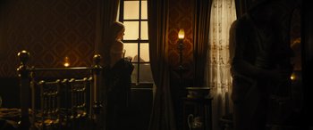 Movie still from “Redeeming Love” (2022), directed by D.J. Caruso – A woman looking out of a window at the sunset; Medium shot, Over the shoulder angle