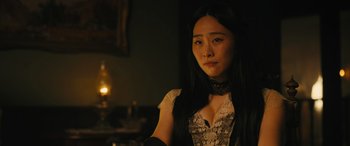 Movie still from “Redeeming Love” (2022), directed by D.J. Caruso – A woman in a black dress and black gloves looking to her left; Close Up shot, Over the shoulder angle