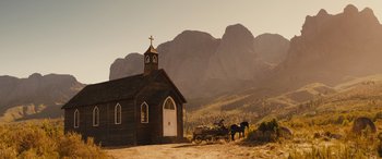 Movie still from “Redeeming Love” (2022), directed by D.J. Caruso – A horse drawn carriage in front of an old church; Extreme Wide shot, Low angle