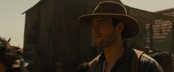 Movie still from “Redeeming Love” (2022), directed by D.J. Caruso – A man wearing a brown hat and a jacket; Close Up shot, Low angle