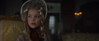 Movie still from “Redeeming Love” (2022), directed by D.J. Caruso – A little girl wearing a dress and a hat; Close Up shot, Over the shoulder angle