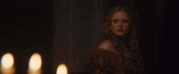 Movie still from “Redeeming Love” (2022), directed by D.J. Caruso – A woman with long blonde curly hair wearing a brown dress; Close Up shot, Over the shoulder angle