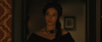 Movie still from “Redeeming Love” (2022), directed by D.J. Caruso – A woman wearing a black dress and a black necklace; Close Up shot, Over the shoulder angle