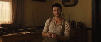 Movie still from “Redeeming Love” (2022), directed by D.J. Caruso – A man holding a pair of scissors in his hands; Medium shot, High angle