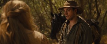 Movie still from “Redeeming Love” (2022), directed by D.J. Caruso – A man wearing a hat standing next to a horse; Close Up shot, Over the shoulder angle