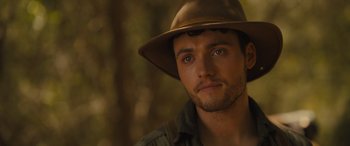 Movie still from “Redeeming Love” (2022), directed by D.J. Caruso – A person wearing a hat with trees in the background; Close Up shot, Over the shoulder angle