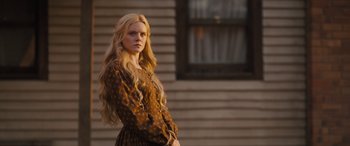 Movie still from “Redeeming Love” (2022), directed by D.J. Caruso – A woman standing in front of a building with long blonde hair; Medium shot, Low angle