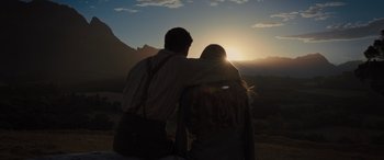 Movie still from “Redeeming Love” (2022), directed by D.J. Caruso – A man and a woman standing next to each other in front of a sunset; Wide shot, Low angle