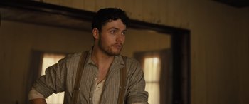 Movie still from “Redeeming Love” (2022), directed by D.J. Caruso – A man with a beard wearing suspenders looking to his left; Close Up shot, Low angle