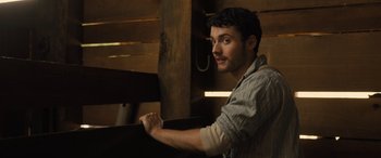 Movie still from “Redeeming Love” (2022), directed by D.J. Caruso – A man sitting in front of a wooden wall; Close Up shot, Over the shoulder angle