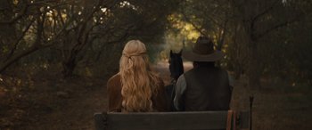 Movie still from “Redeeming Love” (2022), directed by D.J. Caruso – Two people sitting on a bench with a horse in front of them; Close Up shot, Over the shoulder angle