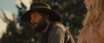 Movie still from “Redeeming Love” (2022), directed by D.J. Caruso – A man with a beard wearing a brown hat; Close Up shot, Low angle