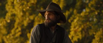 Movie still from “Redeeming Love” (2022), directed by D.J. Caruso – A man with a beard wearing a cowboy hat; Close Up shot, Low angle
