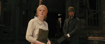 Movie still from “Redeeming Love” (2022), directed by D.J. Caruso – A man and a woman standing next to each other in front of a building; Medium shot, Low angle