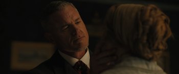 Movie still from “Redeeming Love” (2022), directed by D.J. Caruso – A person wearing a suit and tie; Close Up shot, Over the shoulder angle