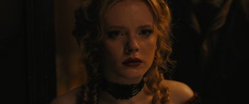Movie still from “Redeeming Love” (2022), directed by D.J. Caruso – A woman with blonde curly hair wearing a black choker; Close Up shot, Low angle