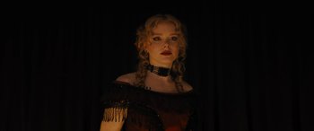 Movie still from “Redeeming Love” (2022), directed by D.J. Caruso – A woman with blonde curly hair wearing a red dress; Close Up shot, Low angle